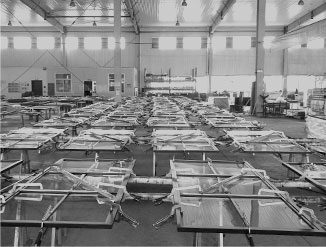 Rows of empty hospital beds in a large indoor facility.