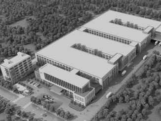 Architectural model of a modern campus with multiple buildings surrounded by trees.