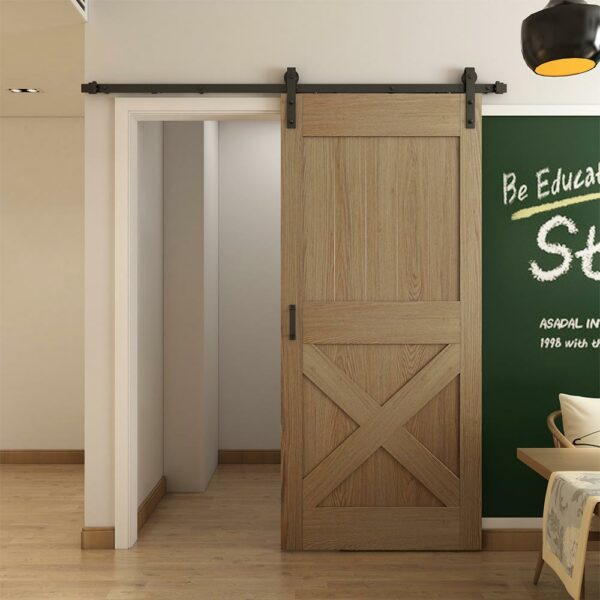 A sliding barn door partially open leading to another room, with a blackboard on the right side of the wall displaying inspirational text.
