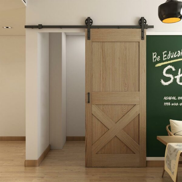 A modern room with a wooden sliding barn door, a blackboard on the wall, and a part of a chair visible.