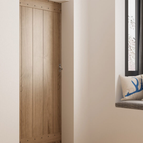 Un alto mobiletto in legno accanto a una finestra con un sedile imbottito vicino alla finestra, un cuscino decorativo e una serratura per la privacy per la porta della stalla.