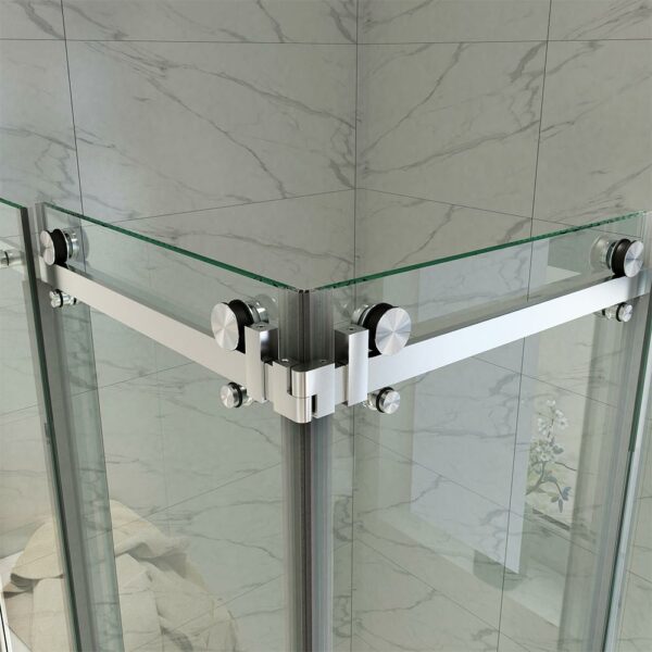 Glass shower enclosure with metal hardware in a marble-tiled bathroom.