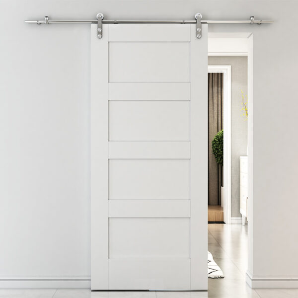 A modern white sliding barn door on a metal track separating two rooms in a well-lit house.