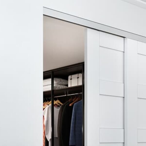 A tidy closet features efficient design with sliding white doors, revealing a clothes rack and boxes on the top shelf.