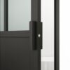A close-up view of a modern, black door handle on a Steel Door with Glass, Loft Style, 4 lites, Swinging Door featuring a silver lock, set against a neutral background.