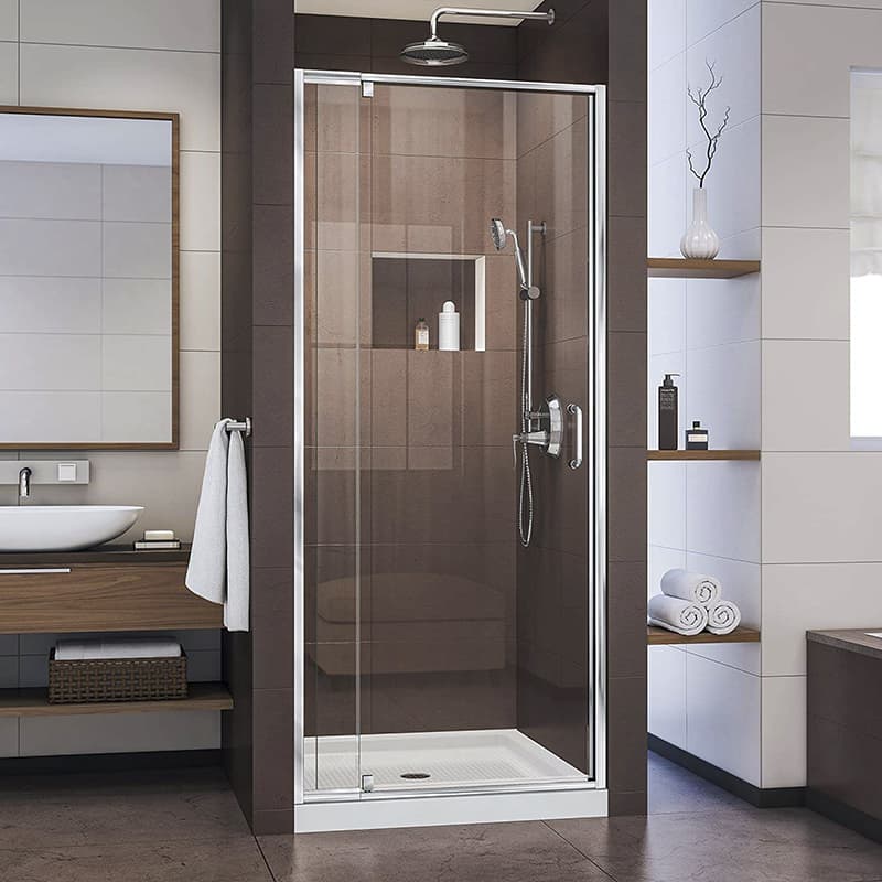 Modern bathroom with glass shower enclosure, towels on a rack, and toiletries displayed on shelves. white and brown color scheme.