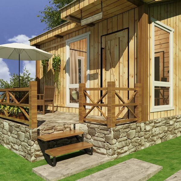 Wooden house exterior with stone foundation, featuring a patio with wooden railing, frameless sliding glass door, chairs, an umbrella, and greenery under clear skies.