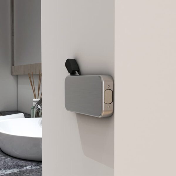 Modern wall-mounted scent diffuser in a minimalist bathroom, partially seen behind a soft-closing sliding door with stainless steel hardware.