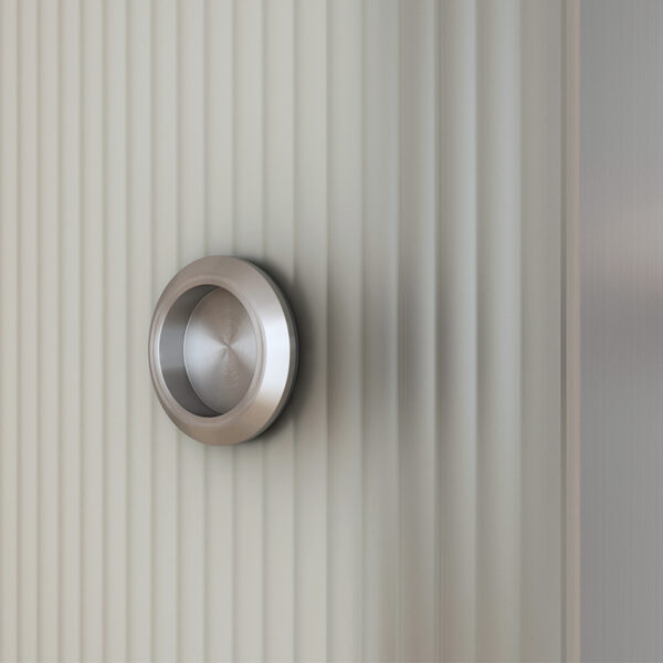 Modern circular handle on an aluminum track sliding glass door with hardware and wood cover.