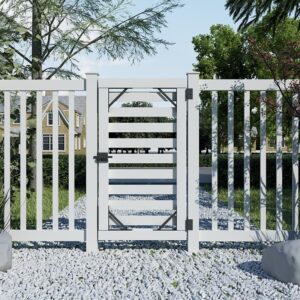 A white picket fence with a matching latch stands on a gravel path, surrounded by trees, shrubs, and houses in the background.