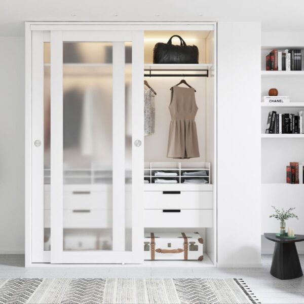 A minimalist wardrobe with white Glass Sliding Closet Doors displays a handbag, clothes, drawers, and a suitcase; nearby shelves hold books and decor.