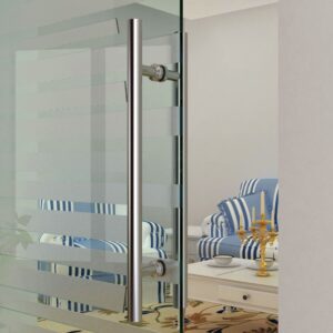 A glass door reveals a room with blue-and-white striped furniture and a candelabra, highlighted by a Double-Sided H-Shaped Brushed Stainless Steel Barn Door Handle.