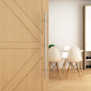 A sliding wooden door with a stainless steel handle reveals a room with a table and four white chairs.