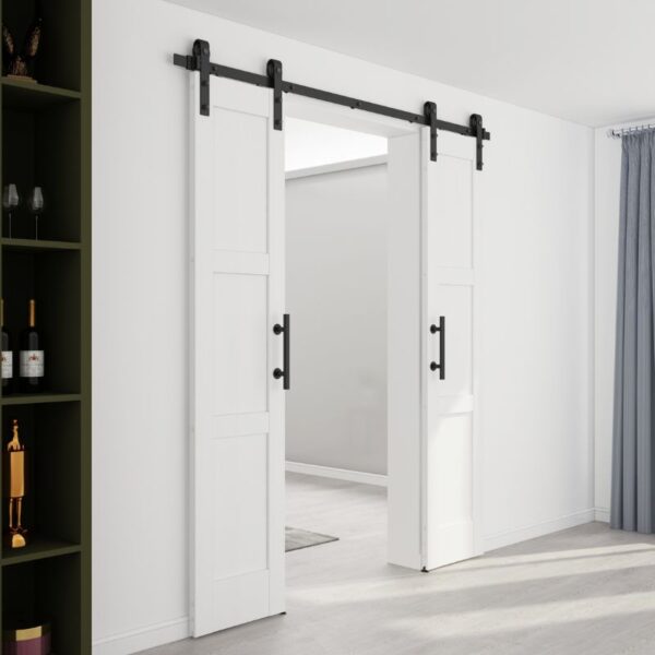 Partially open white sliding barn door with black handles in a minimalist room; shelving with bottles left, curtain right.