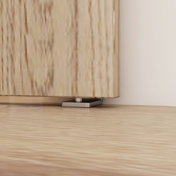 Close-up of an adjustable cabinet foot on light wood flooring, matching the Brushed Nickel Floor Guide for sliding barn doors.