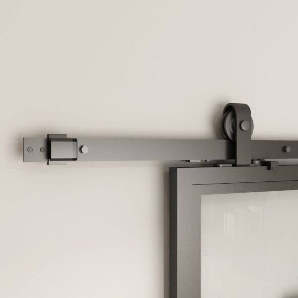 Close-up of the sliding glass barn door mechanism: metal track and roller on wall, supporting frosted tempered glass.