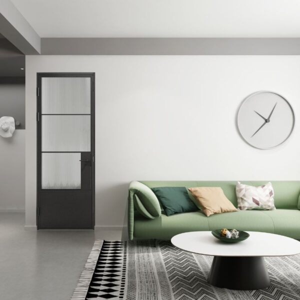 The minimalist living room features a green sofa, geometric rug, round table, wall clock, black glass barn door, and a white sculpture.