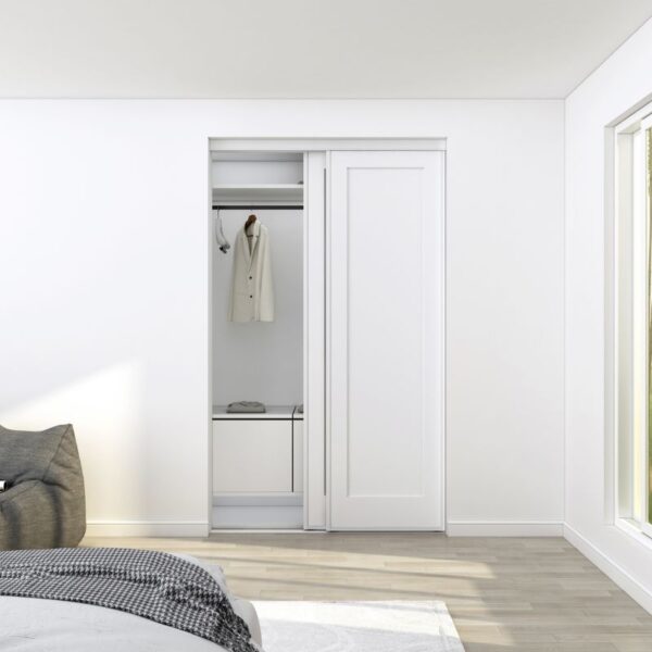 A steel and MDF single-panel closet door reveals a jacket and folded shirt. This minimalist bedroom has beige floors and a large window.