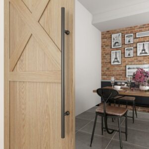 A dining area featuring a wooden sliding door with a customizable black steel pull, metal chairs, and Eiffel Tower pictures on a brick wall.