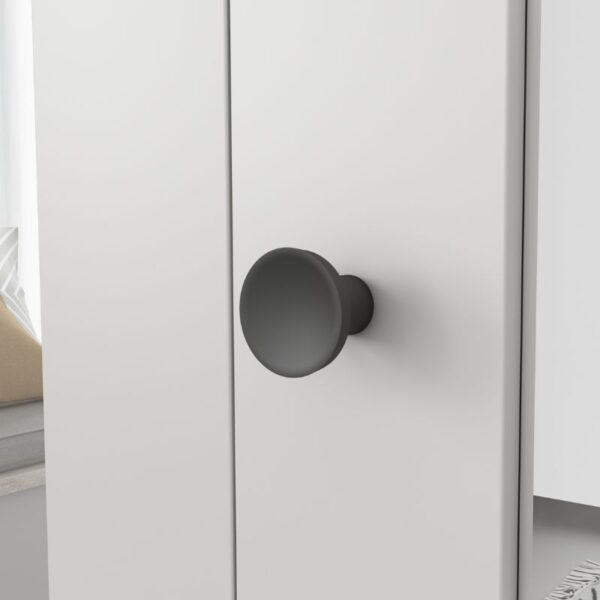 Prim-plan al unui buton negru mat pe o ușă pliantă albă cu oglindă; camera se vede ușor în fundal.