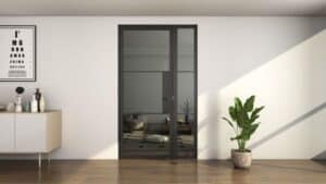 Modern room with metal frame glass doors, white walls, sideboard, decor items, eye chart, plant, and wood floors.