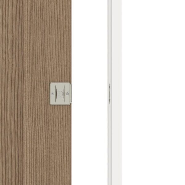 Gros plan d'une porte en bois partiellement ouverte avec une serrure de porte de poche en nickel brossé et une partie d'un cadre blanc visible.