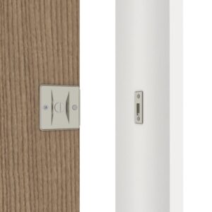 Gros plan d'une serrure de porte coulissante en nickel brossé sur une porte en bois, avec une plaque de verrouillage assortie sur un cadre blanc.