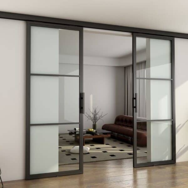 Porte de grange coulissante en verre avec cadre en acier et quincaillerie en aluminium pour séparer un salon meublé. Commandes sur mesure possibles.