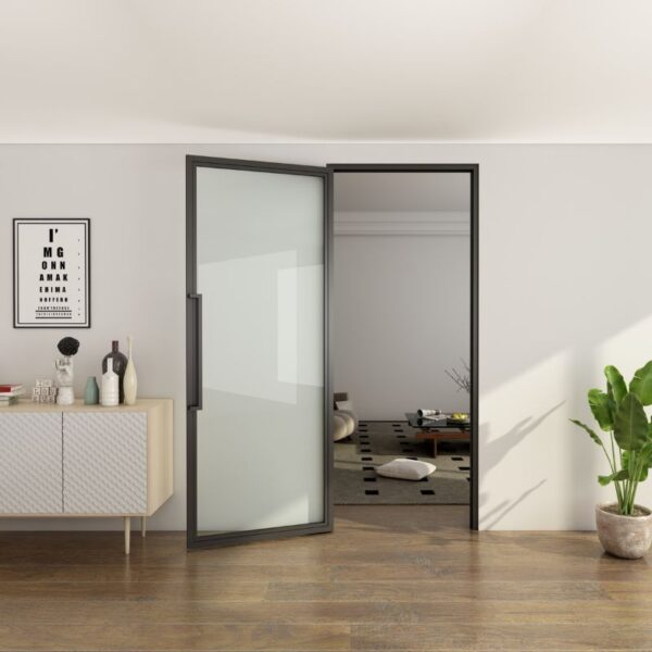 A matte black glass steel swing door is partly open between rooms, with a sideboard and decor in front and cushions behind.
