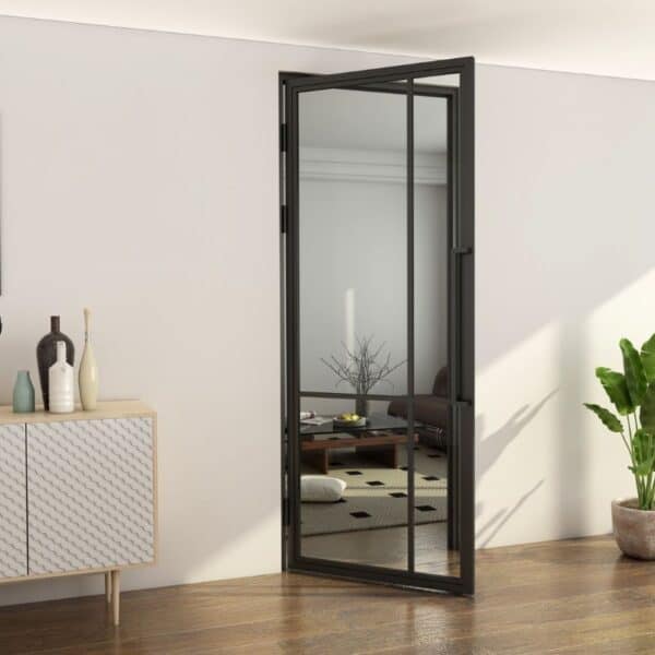 Partially open black steel French door with glass in a minimalist living room with wood floors, plant, and white cabinet.