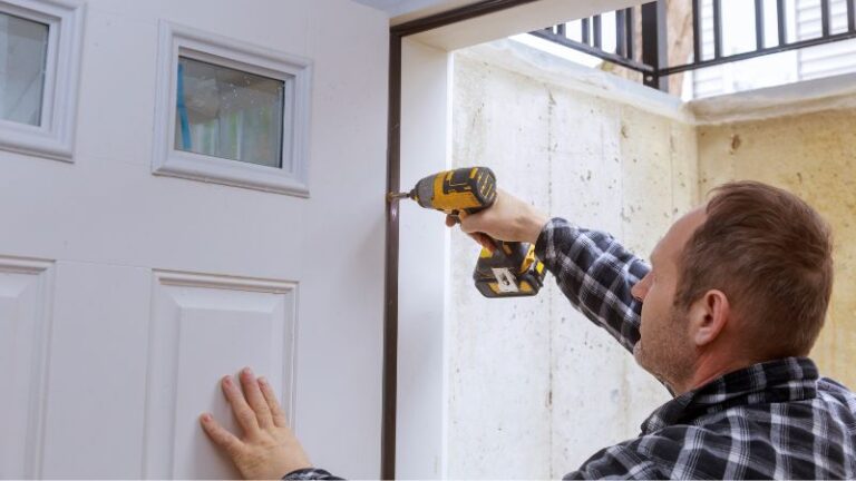 Homem instalando uma porta de celeiro com uma furadeira elétrica, demonstrando técnicas de fixação segura para um interior rústico.