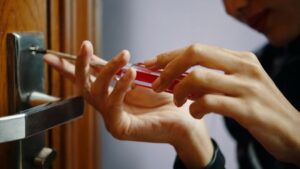 Close-up of a person installing a barn door handle using a screwdriver on a wooden door. Focus on precise placement for optimal functionality and aesthetic appeal.
