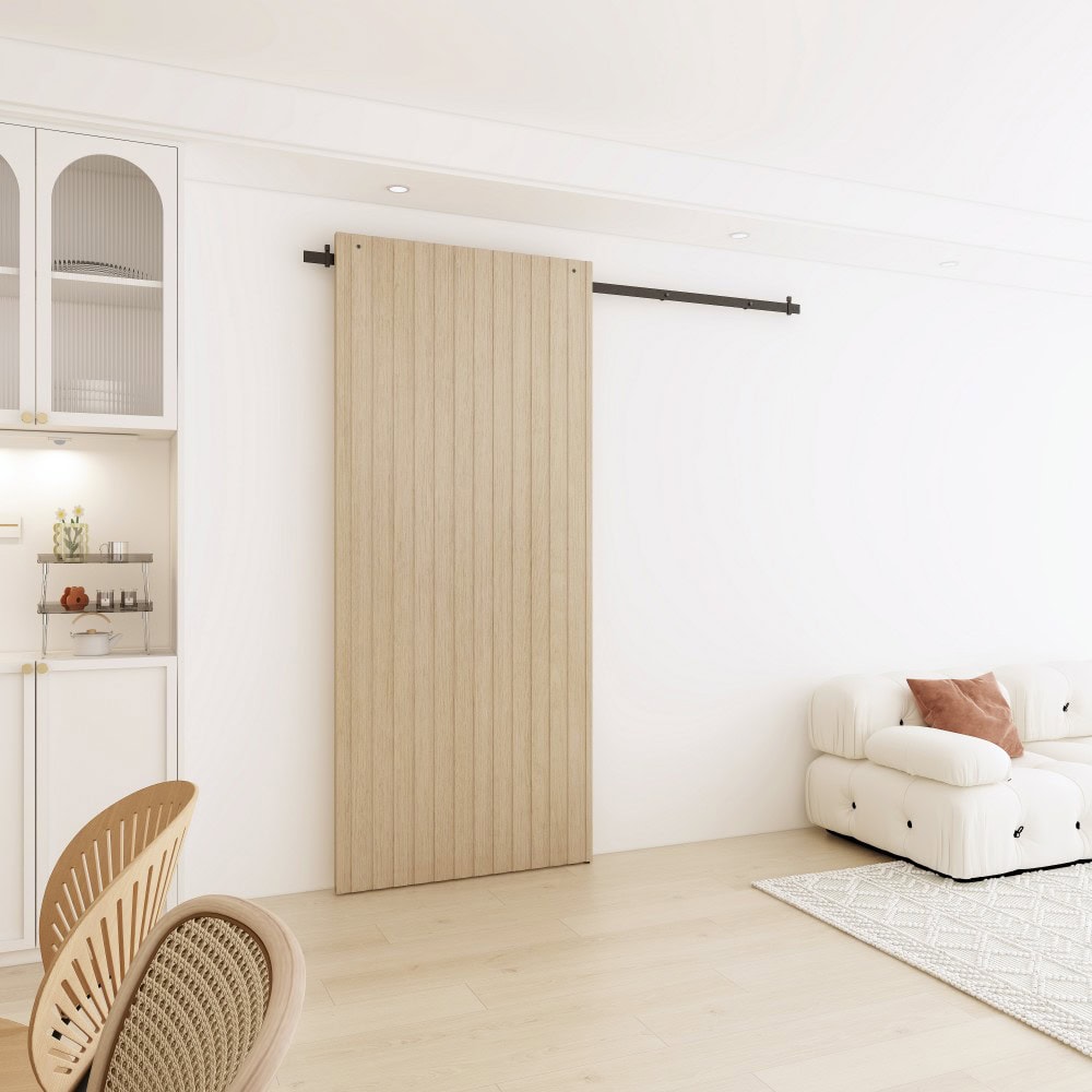 Modern concealed sliding barn door system with black hardware in a minimalist living room setting.