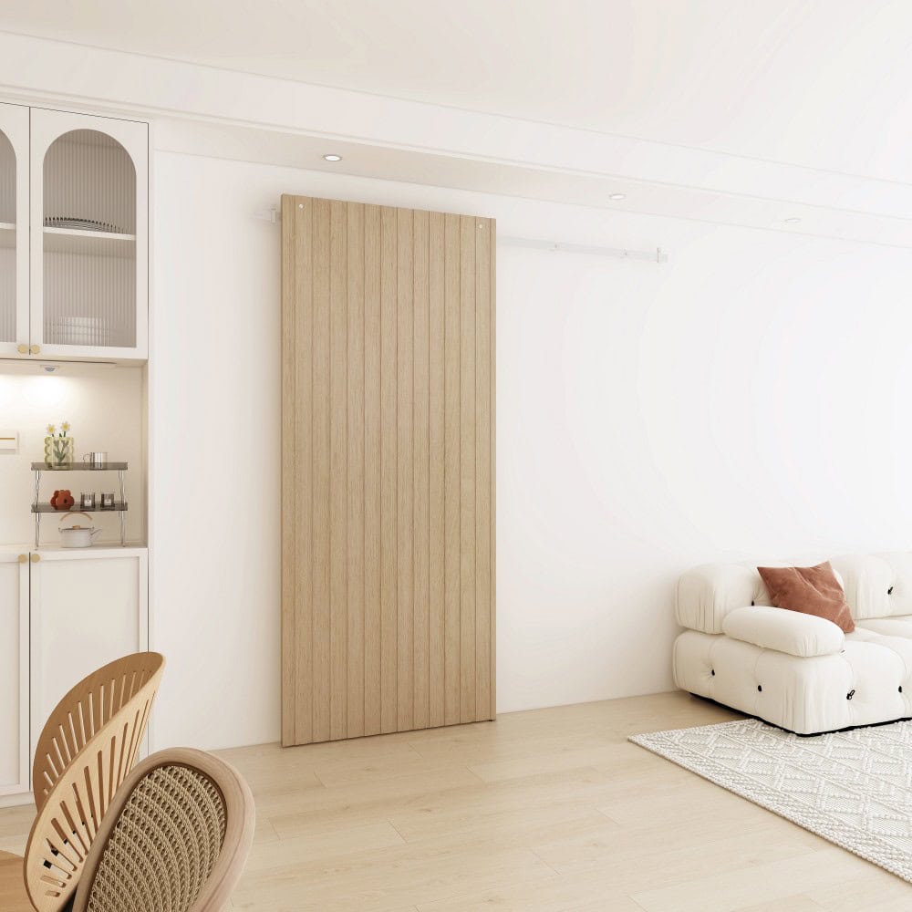 Bright and airy living room with white walls, beige wooden panel, white sofa, and light wood flooring, creating a minimalist and cozy atmosphere.
