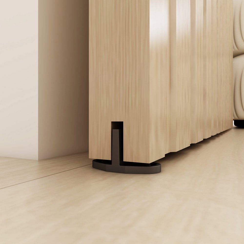 Close-up of a black floor guide for a concealed sliding barn door system, showcasing sleek design and smooth operation.