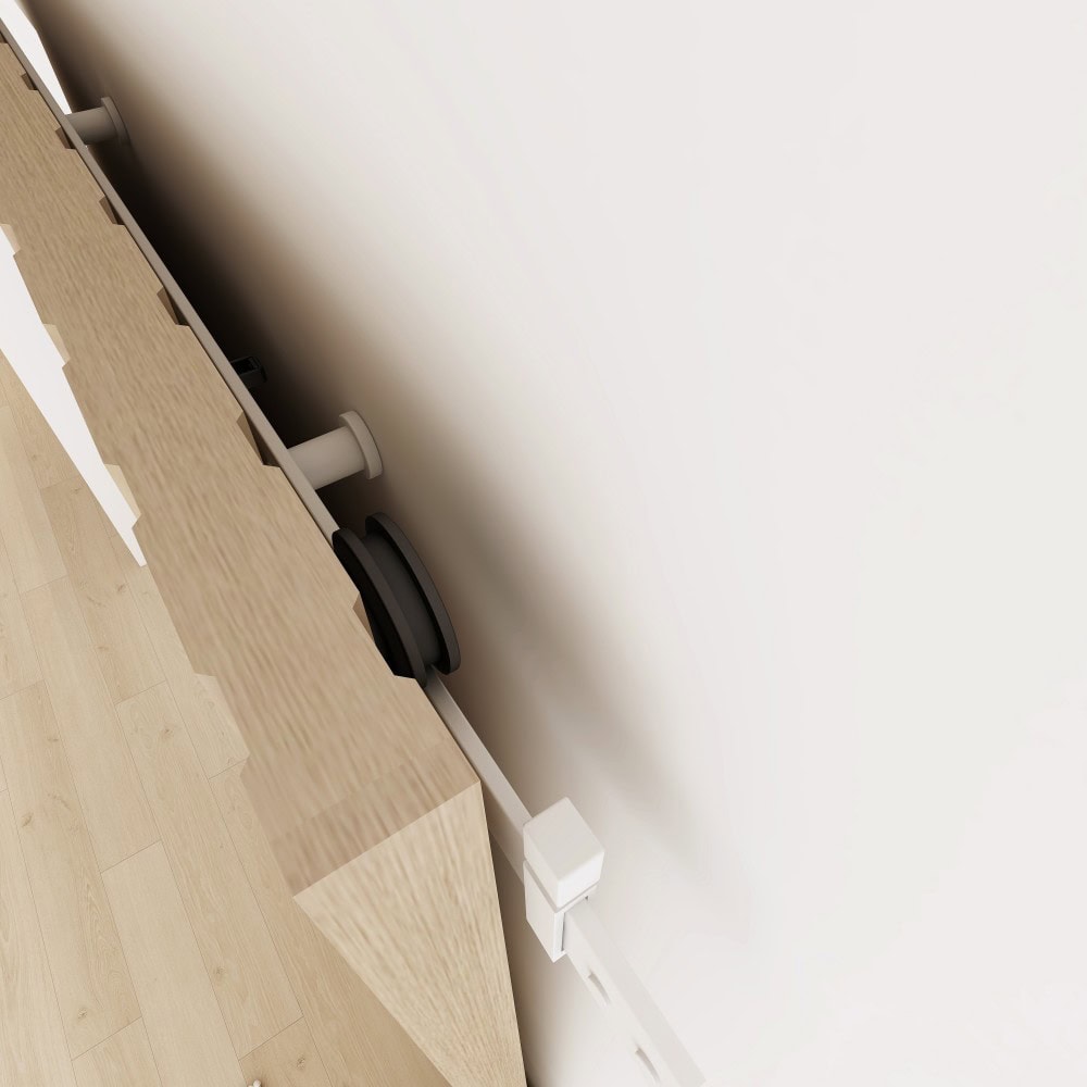 A modern office desk with a wooden surface, a black wireless speaker, and a white power outlet on a white wall.