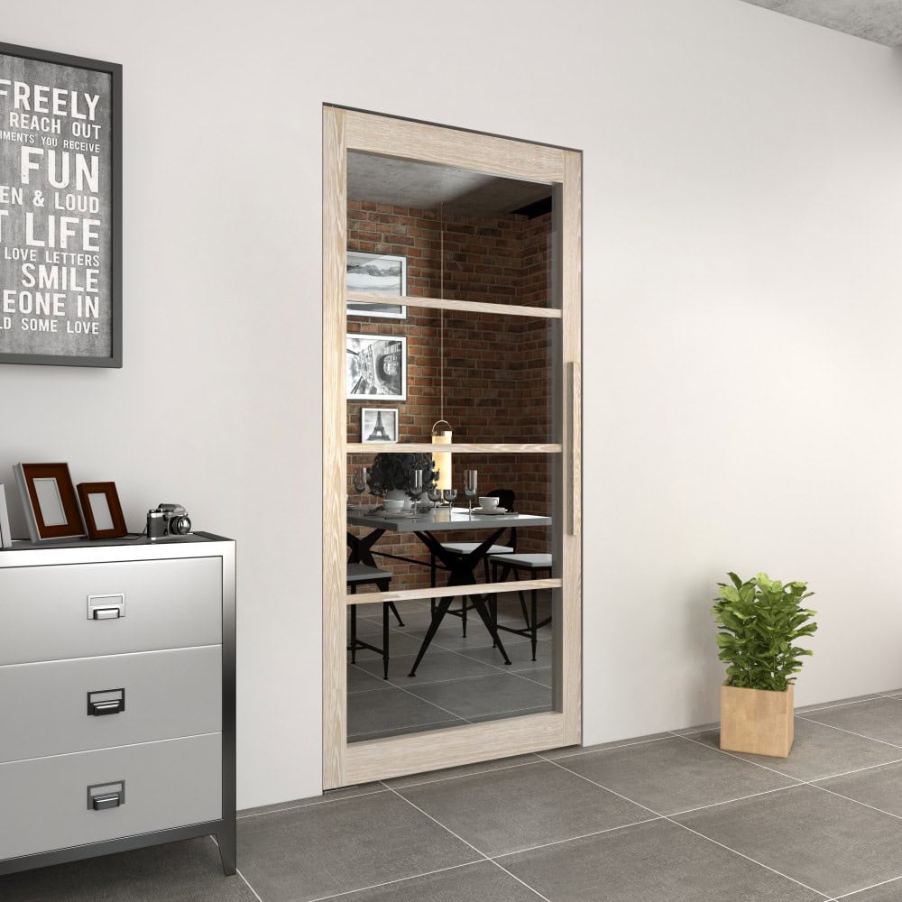 Modern wood and glass pivot door with hardware set, leading to a stylish dining area with brick wall and contemporary decor.