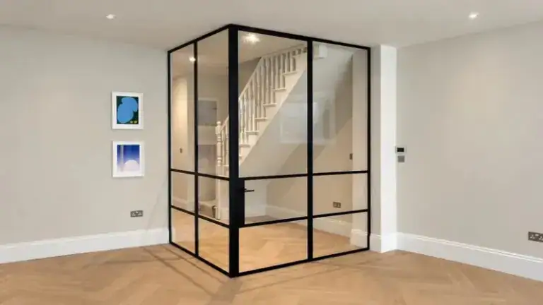 Elegant steel-framed glass partition surrounding a staircase, enhancing space openness and modern aesthetic in a contemporary interior.