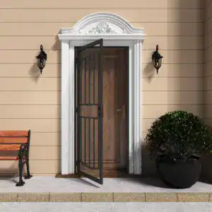 Black steel security screen door with arched design and expanded metal mesh, installed at a residential entrance with decorative white trim and outdoor lighting.